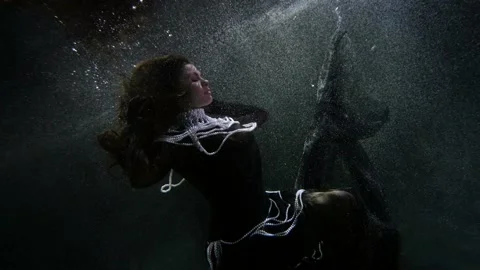 Magic and dream concept, elegant brunette woman is keeping afloat underwater Video stock 167376193