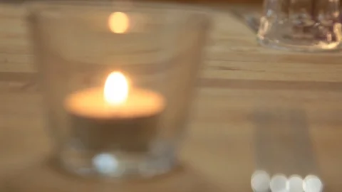 Magic candle fire into a glass on table near the fork Stock Footage 113139042