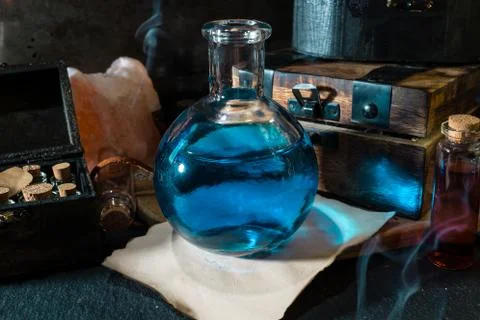 Magic concept. Blue Potion in bottle and wooden box Stock Photos