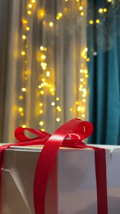 Magic dust falling on white gift box with red bow, satin ribbon Stock Footage 297206249