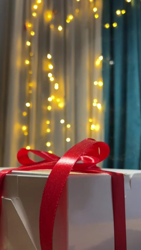 Magic dust falling on white gift box with red bow, satin ribbon Stock Footage 304764793