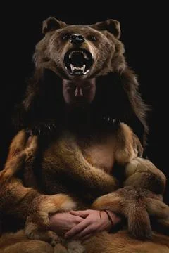 Magic fighting shaman werewolf man with a beard in a fur dress in a dark room Stock Photos