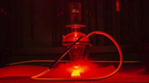 Magic hookah smoke with red lights. Design glass hookah with metal frame. Ill Foto stock