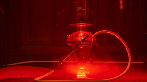 Magic hookah smoke with red lights. Design glass hookah with metal frame. Ill Foto stock