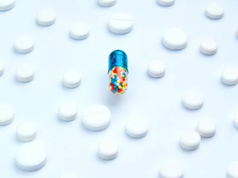 Magic pill concept. A large tablet capsule with multi-colored filling is in t 스톡 사진