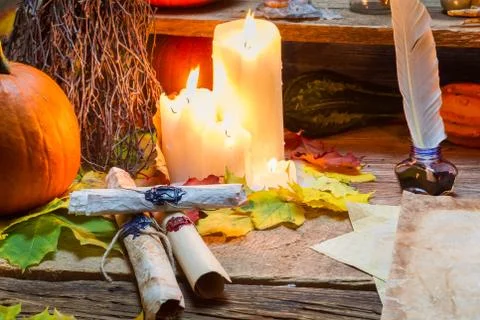 Magic scrolls and candle on the old scribe table Stock Photos