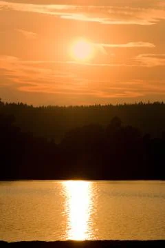 The magic sunset is mirrored on the water surface . Stock Photos