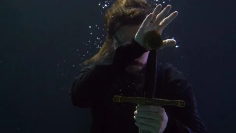 Magic sword in hands of brave and enigmatic knight in dark mysterious depth of 스톡 동영상 167278463