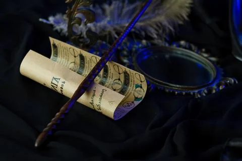 A magic wand rests on a scroll of spells Stock Photos