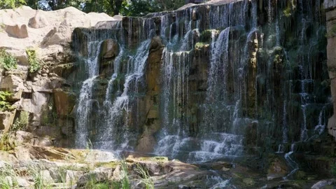 Magic waterfall streaming down a sheer stone wall on a sunny day in summer 库存影片 164586217