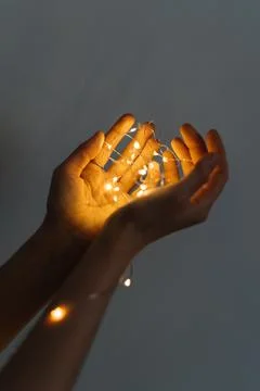 Magic is in your hands. a thread of glowing Christmas garland in your hands Stock Photos