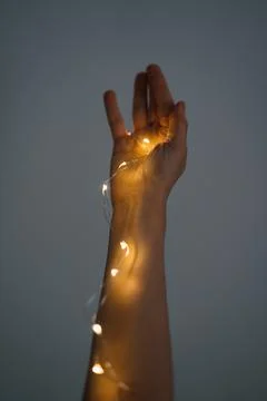 Magic is in your hands. a thread of glowing Christmas garland in your hands Stock Photos