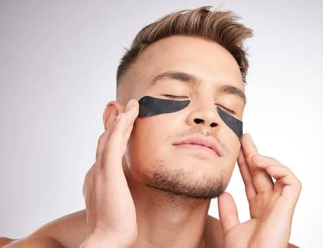 Magic for your under-eyes. Studio shot of a young man wearing under-eye patches Stock Photos