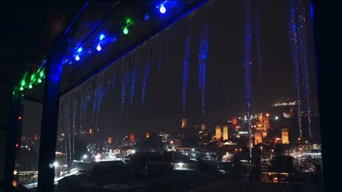 Magical night balcony window view framed with icicles and glowing colorful .. Vídeos de archivo 342130748