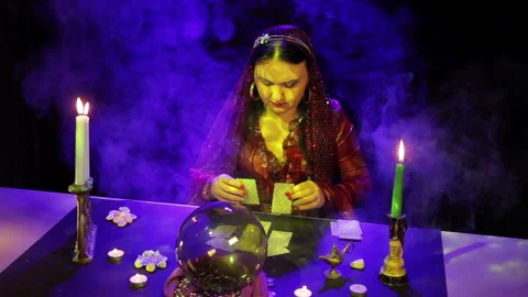 In the magical salon gypsy lays out the cards on the table in the glare Stock Footage 102960853