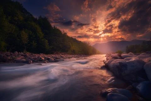 Magical sunset over fast flowing mountain river Stock Photos