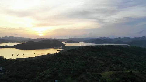 Magical sunset zoom behind tiny tropical islands in the sea Coron 4K Drone Clip Stock Footage 102864040