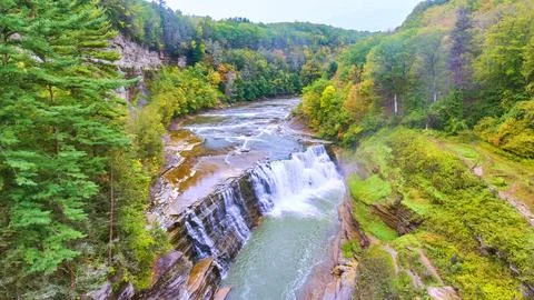 Magical waterfall hidden in woods eroding cliffs with fall foliage around Foto stock