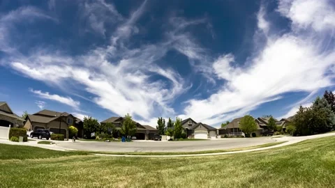 Magically wispy clouds scroll over the homes in this idyllic suburban Stock Footage 155625065