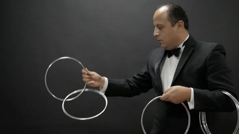 Magician doing tricks using metal rings Stock Footage 124195558