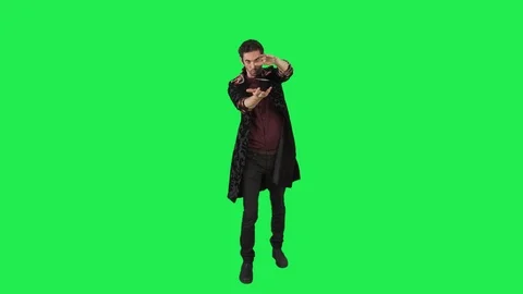 A magician performs a magic trick of a flying card over a green screen, Stock Footage 104140065