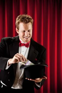 Magician: Pulling Stack of Bills Out of Magic Hat Stock Photos