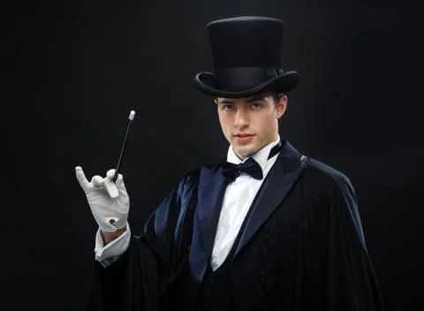Magician in top hat with magic wand showing trick Stock Photos