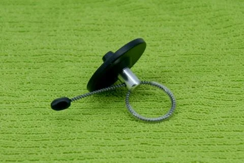 Magnetic bottle security tag on a green fabric Stock Photos