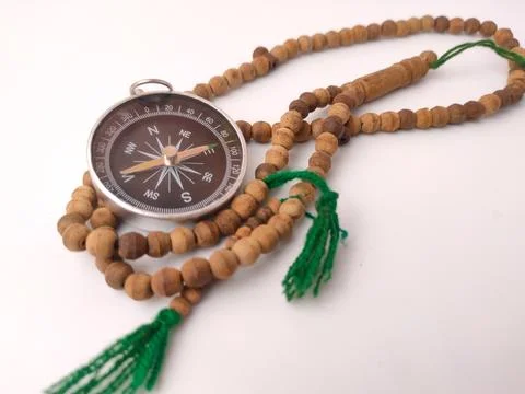 A magnetic compass resting inside the loops of a traditional wooden prayer .. Foto stock