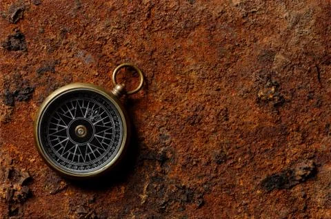 Magnetic compass on rough rusty background Stock Photos