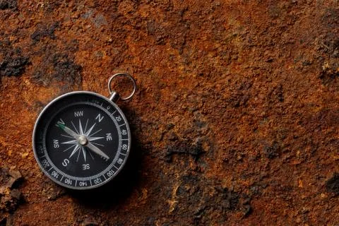 Magnetic compass on rough rusty background Stock Photos