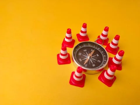 Magnetic compass used for navigation, placed on a yellow surface surrounded.. Stock Photos