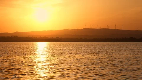 Magnificent dramatic red sunset on lake. Windmills in background. Concept of Stock Footage 114448734
