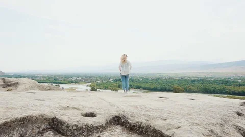 Magnificent view in Georgia from cliff edge, girl with blond flying hair in Stock Footage 105968637