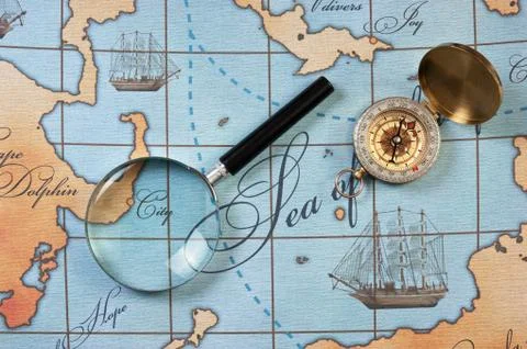 Magnifier and compass on  map Stock Photos