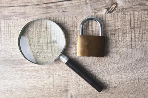 Magnifier and lock on the table Stock Photos