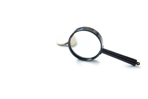 Magnifier and stack of coins isolated on white background Stock Photos