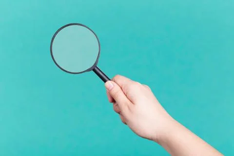 Magnifier in hand Stock Photos
