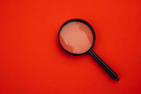 Magnifier on red Stock Photos