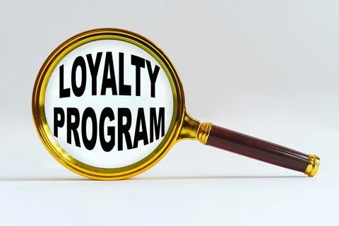 Magnifier on a white background, inside the text is written - LOYALTY PROGRAM Stock Photos