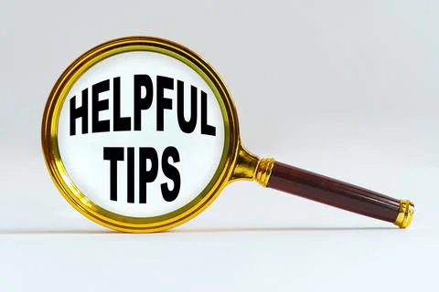 Magnifier on a white background, inside the text is written - HELPFUL TIPS Stock Photos