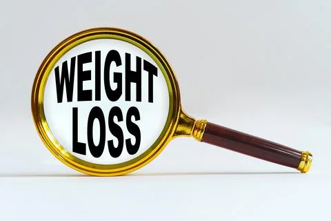 Magnifier on a white background, inside the text is written - WEIGHT LOSS 库存照片