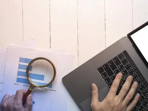 Magnifying glass and documents with analytics data lying on table,selective.. Stock Photos