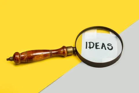 A magnifying glass and ideas word write on a paper Stock Photos
