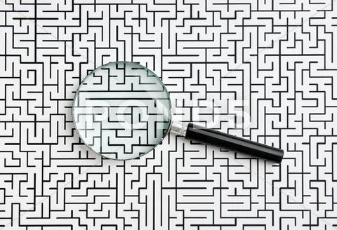 Magnifying glass and labyrinth Stock Photos