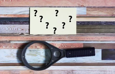 Magnifying glass and question marks on a beautiful background. Search for i.. Stock Photos