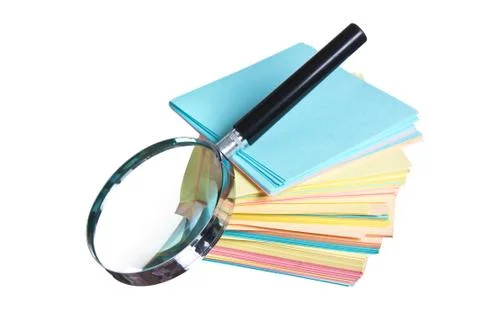 Magnifying glass and a stack of paper Stock Photos