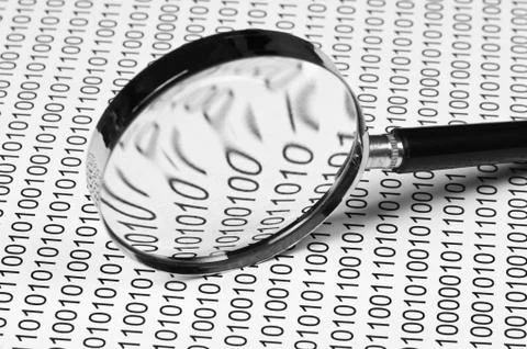 Magnifying glass on a binary code Stock Photos
