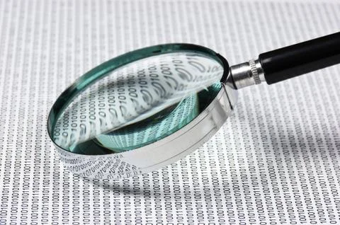 Magnifying glass on a binary code 写真素材