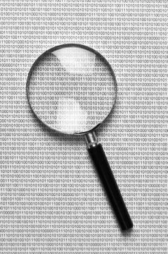 Magnifying glass on a binary code 스톡 사진